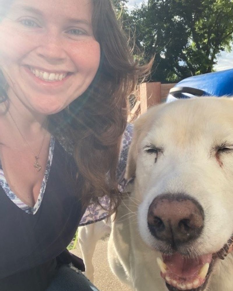 Callie Selin hugging a yellow lab